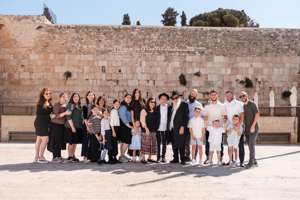Extended family portrait with the Western Wall in the background