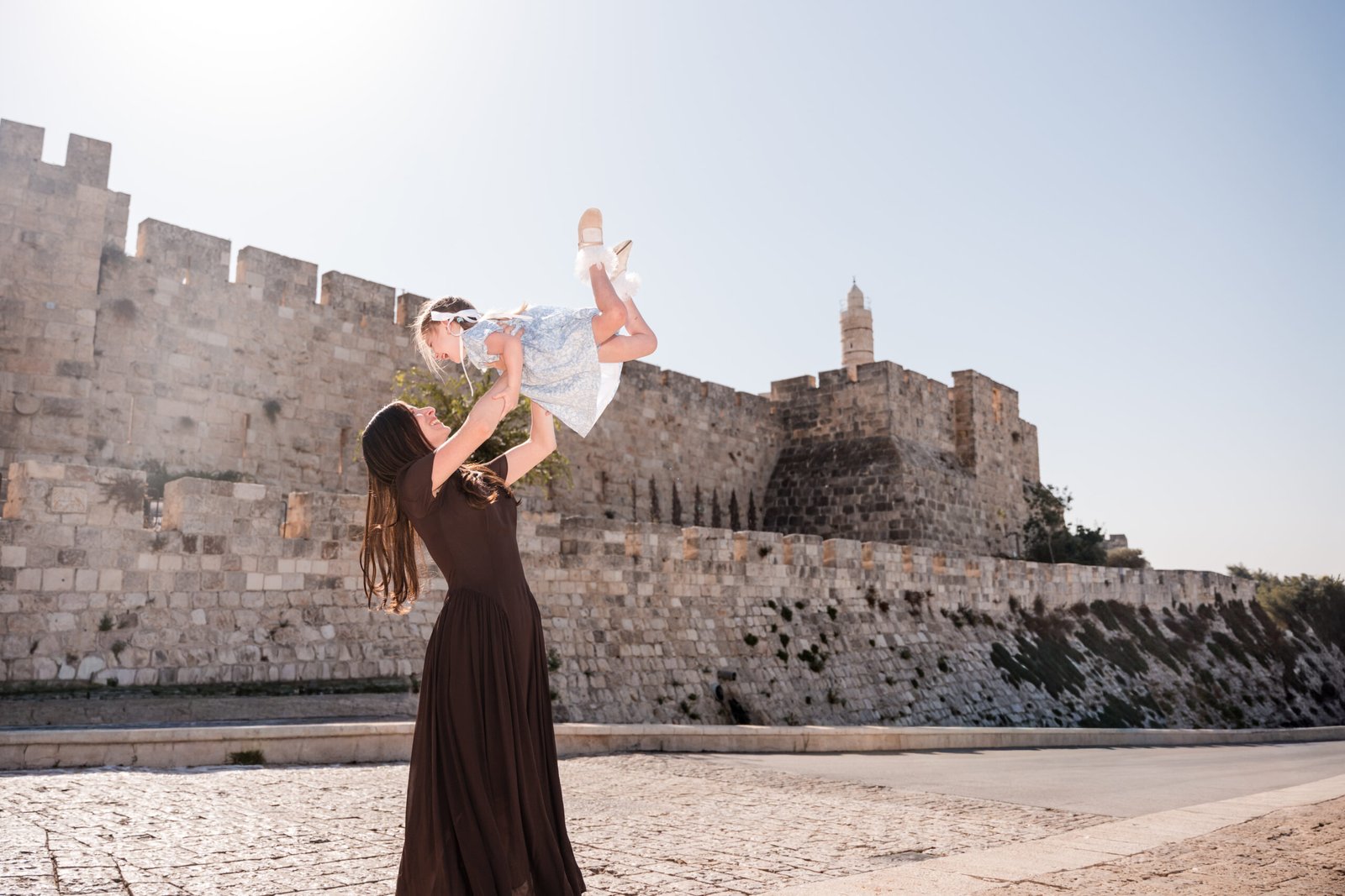 Mother lifting her daughter with the Tower of David in the background, Jerusalem.
