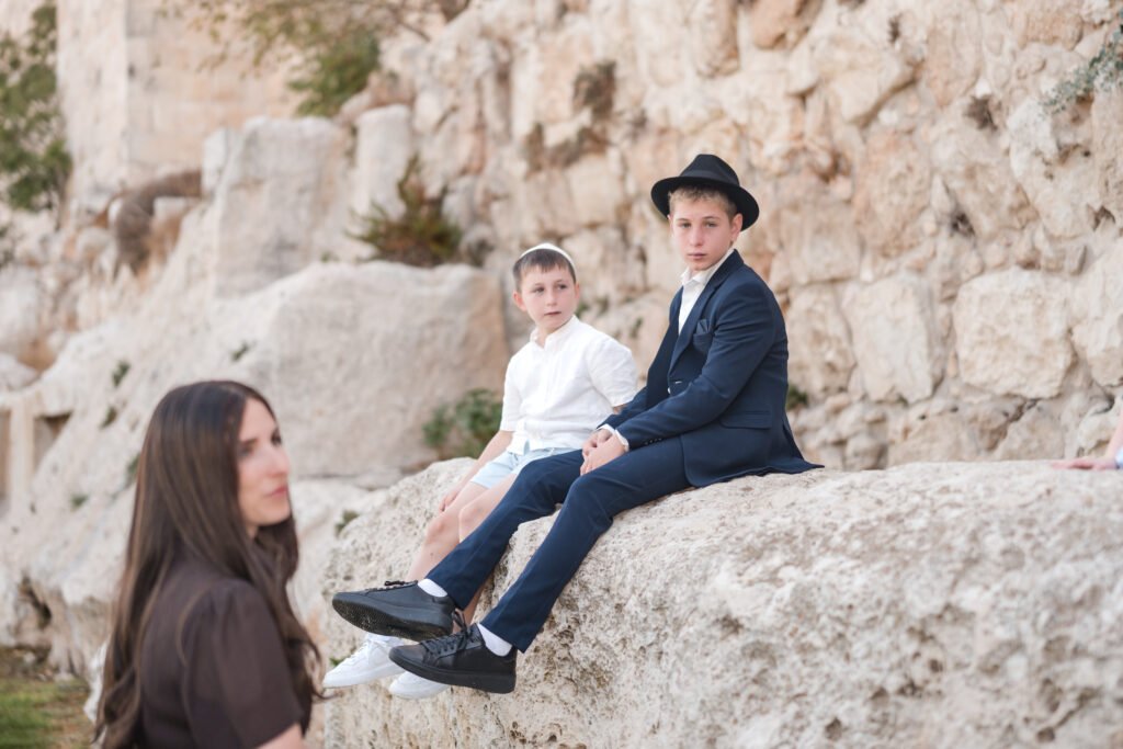 Bar Mitzvah boy sitting on the stones in Jerusalem’s Old City.