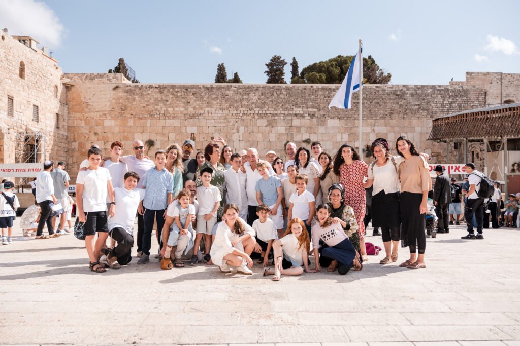 Large family group gathered for a photograph at the Western Wall plaza