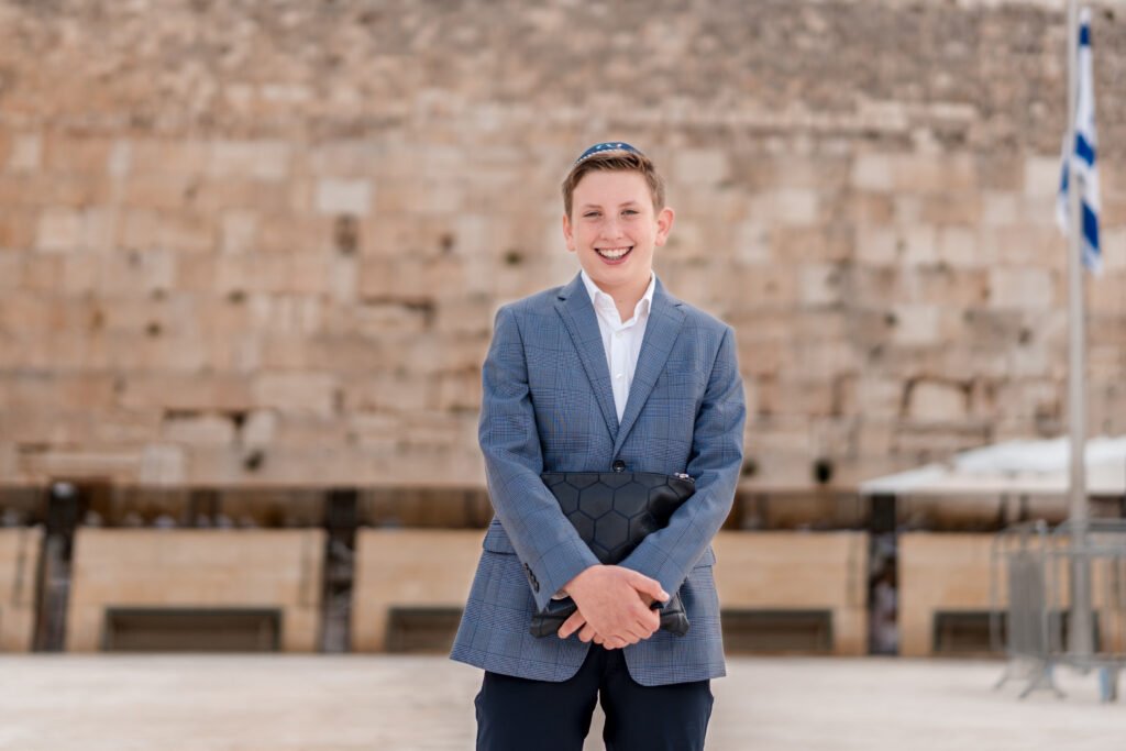 Bar mitzvah portrait in a blue jacket with the Kotel in the background